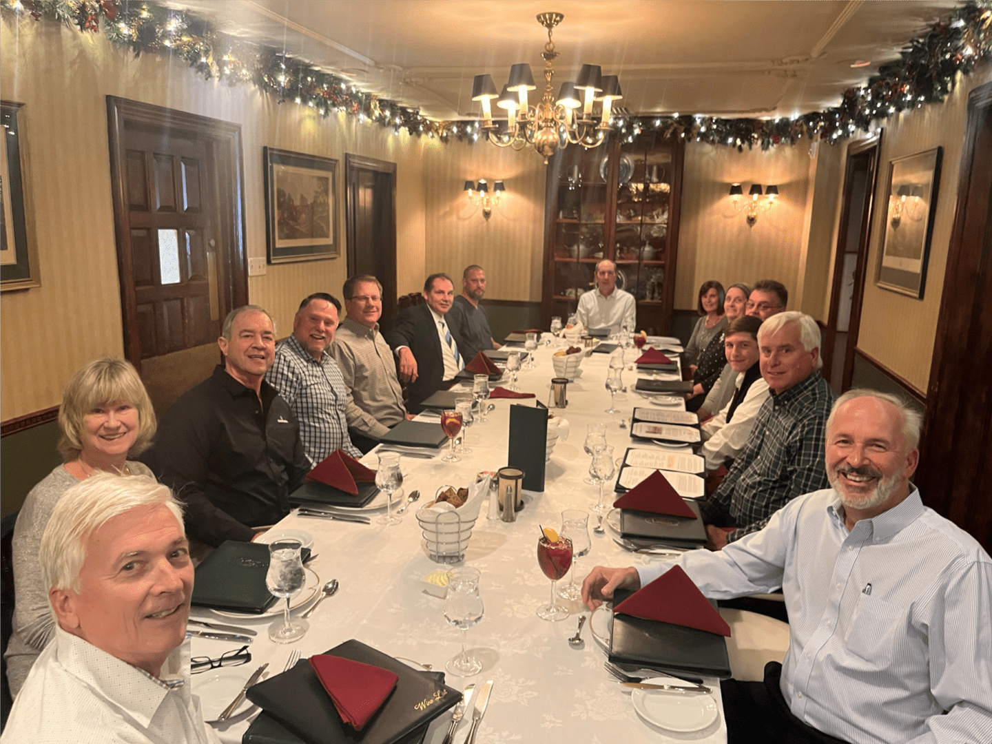 A group of people sitting at the table in front of plates.