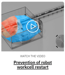 Robot vacuum stuck on a red and blue mat near stairs.