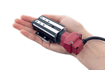 A small linear rail guide with a red end, held in a hand.