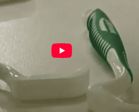 Green-striped toothbrush on soap dish