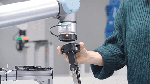 Person guiding robotic arm gripper