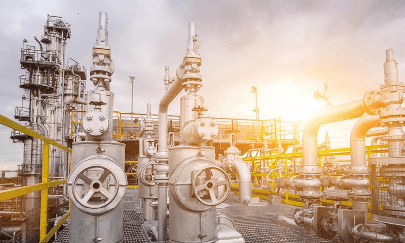 Oil refinery pipes and valves at sunset